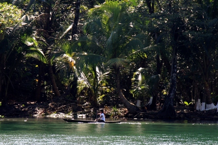 Junge Frau auf dem Einbaum unterwegs